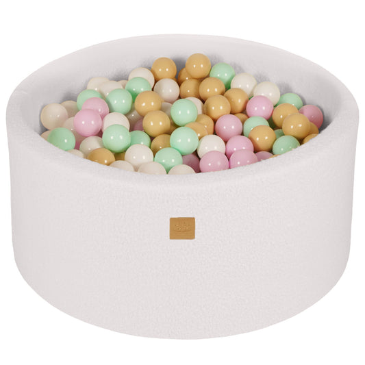A white round boucle ball pit filled with colorful balls, suitable for children's play.