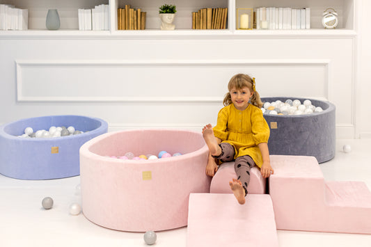 Round pink ball pit filled with pastel play balls