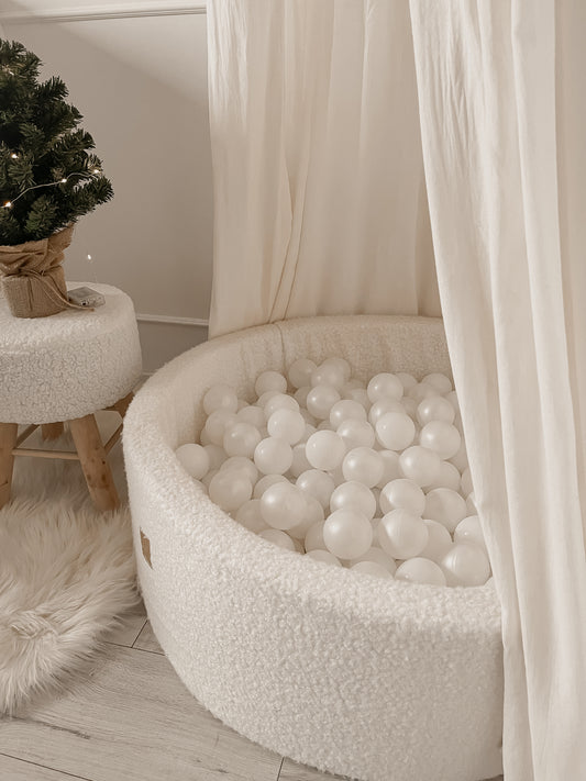 Velvet round ball pit with white and transparent balls.