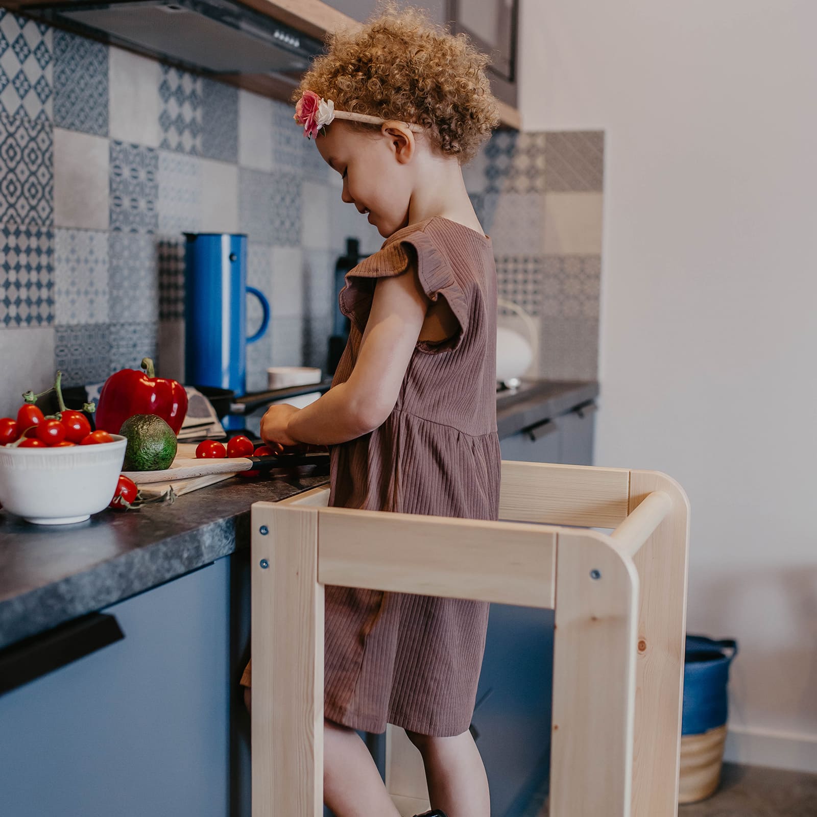 Toddler helping on a kitchen helper stool in the kitchen.