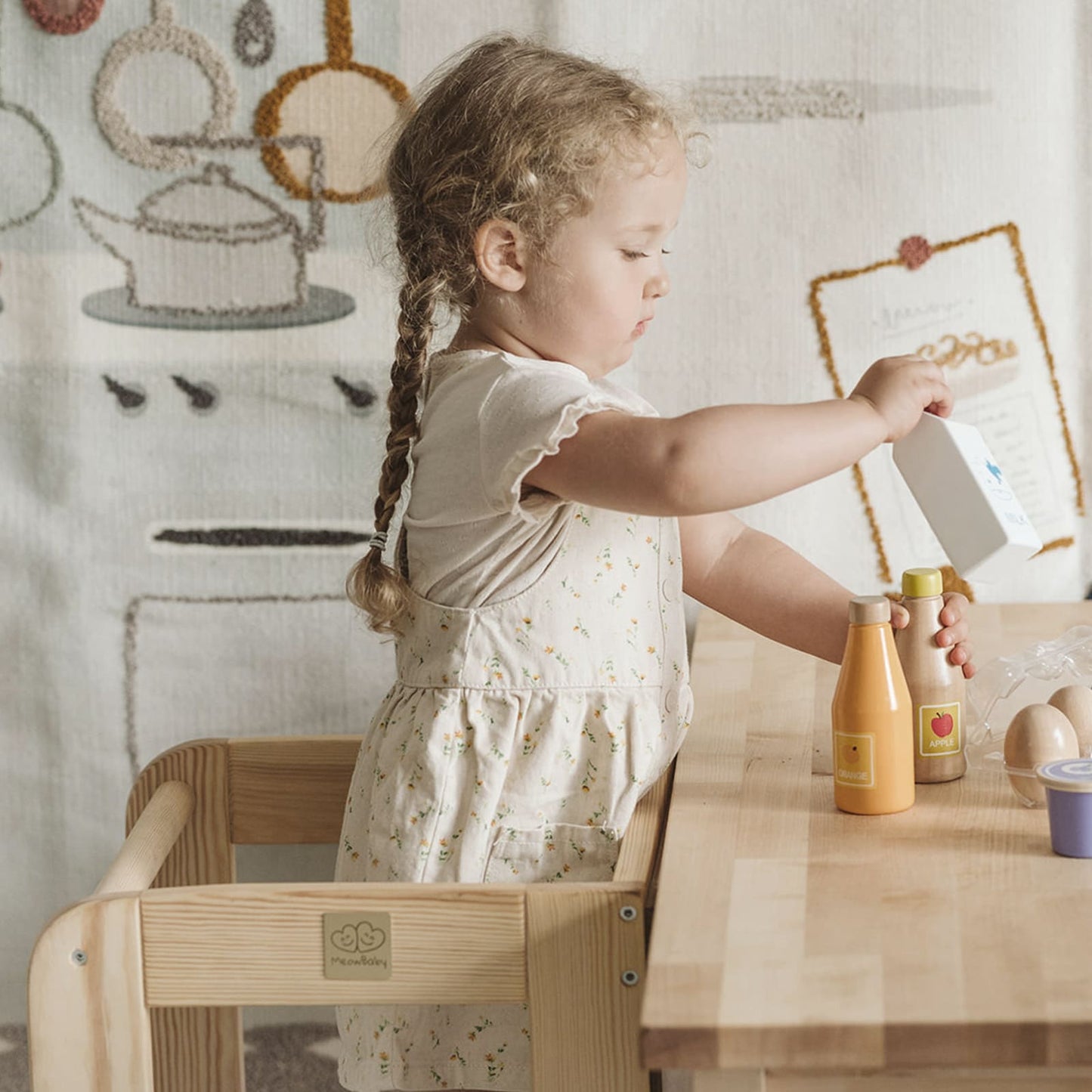 Close-up of a toddler playing on a kitchen helper stool in a kitchen.