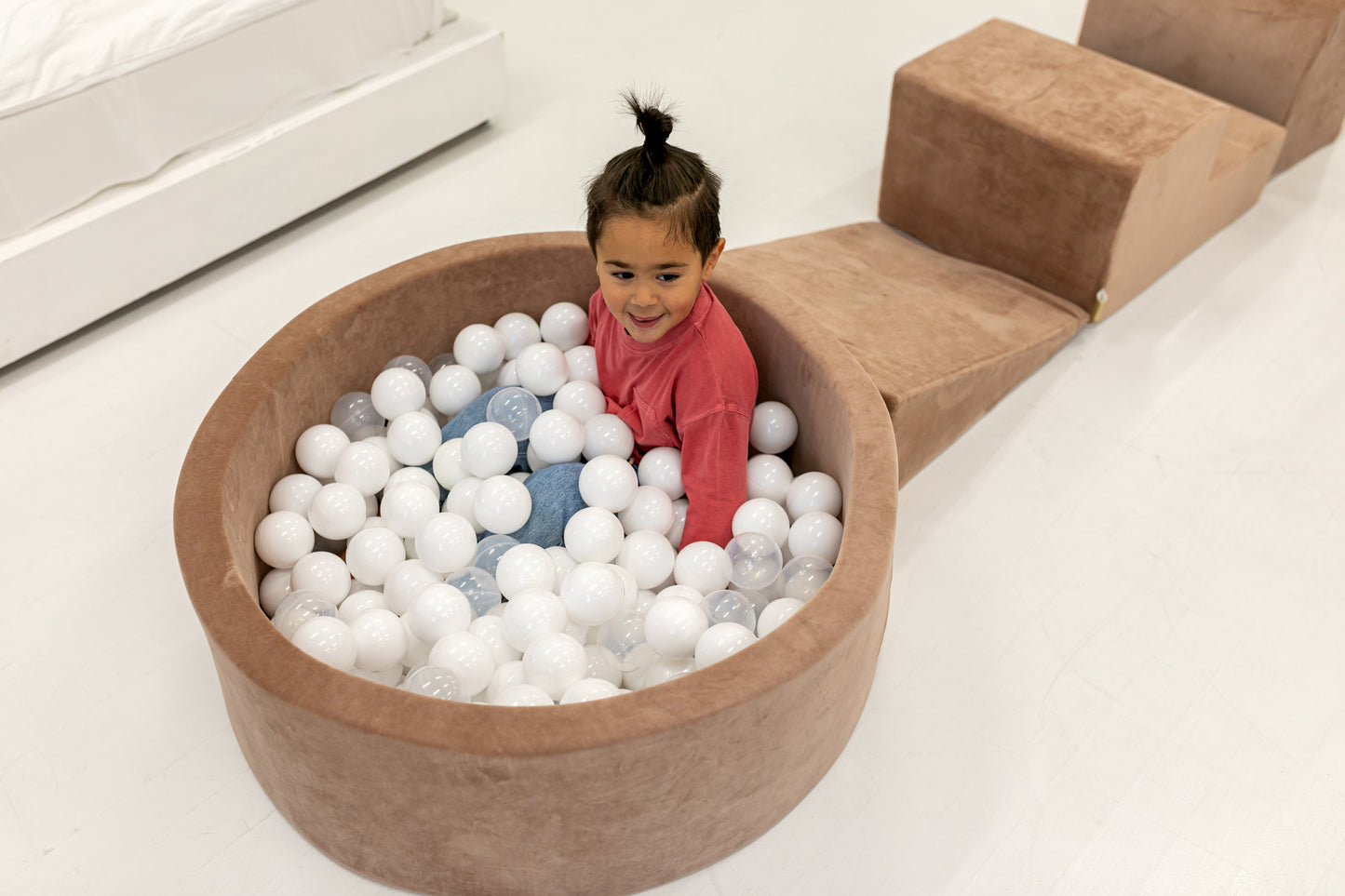 Round brown ball pit for children filled with play balls