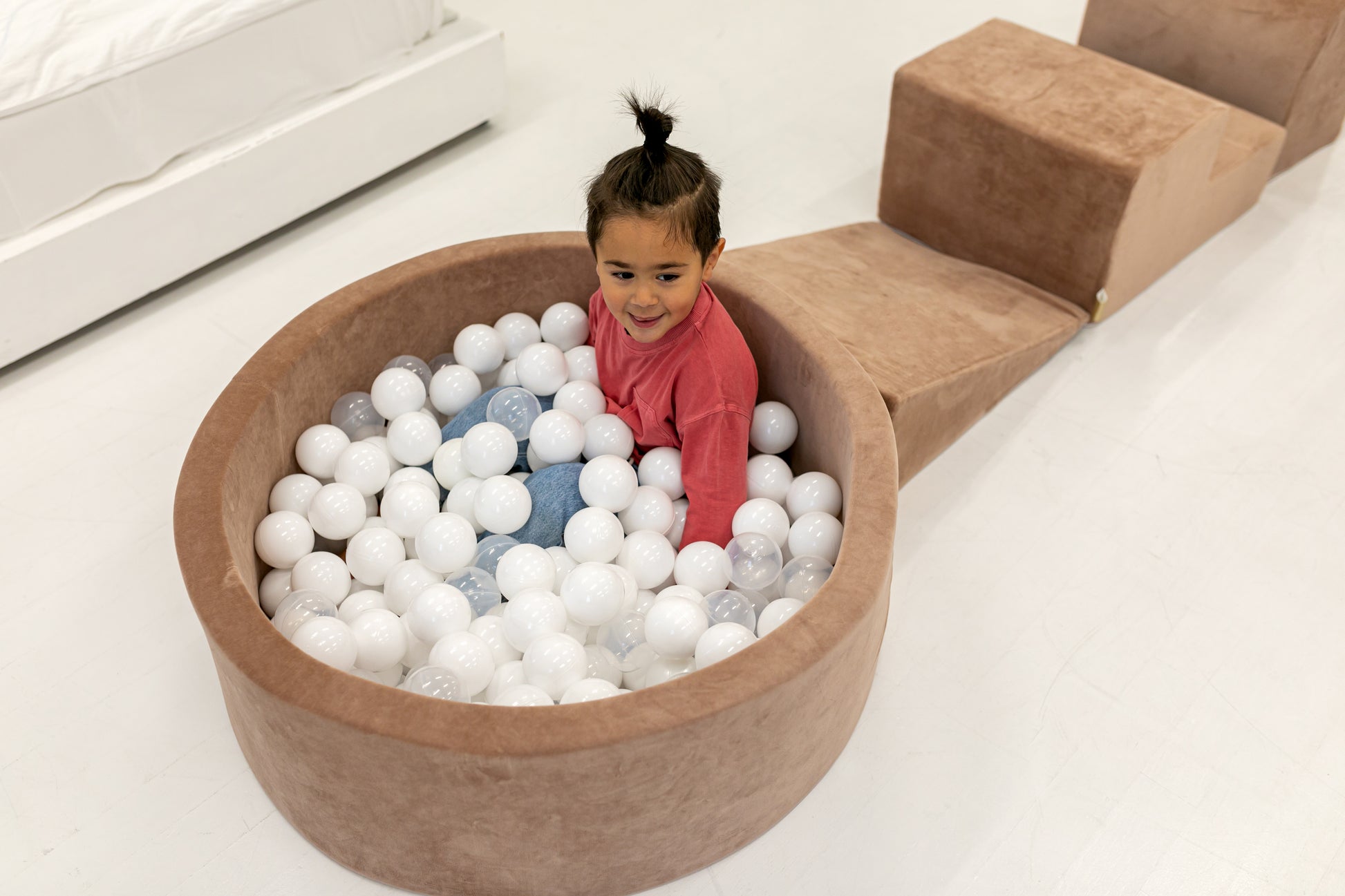 Round brown ball pit for children filled with play balls
